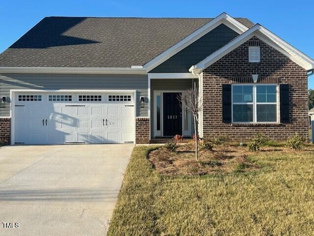 1917 Darrell Dr Unit 5, Graham, NC 27253 - view of front facade with concrete driveway, brick siding, an attached garage, and a front yard