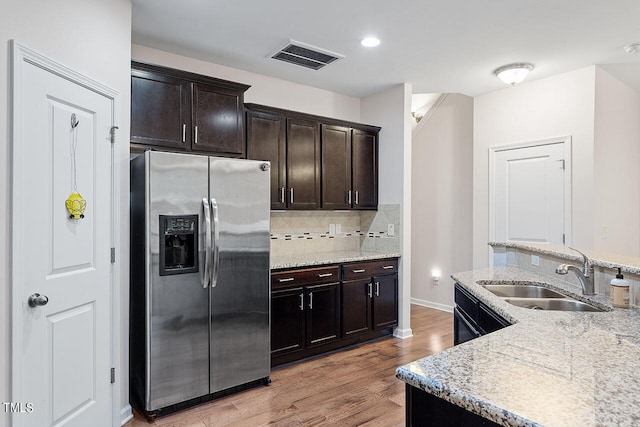 kitchen featuring light wood-type flooring, dark brown cabinetry, sink, and stainless steel fridge with ice dispenser