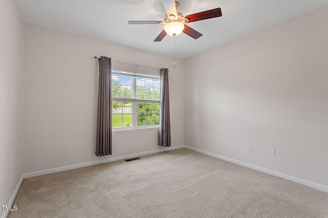 carpeted spare room featuring ceiling fan