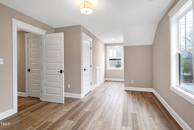 additional living space with a wealth of natural light and light wood-type flooring