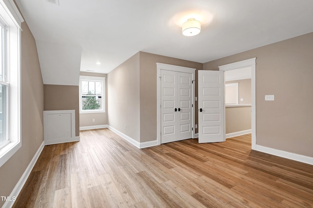 additional living space with light hardwood / wood-style flooring