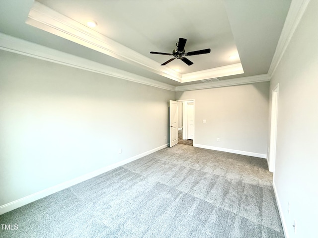 carpeted spare room featuring visible vents, a raised ceiling, a ceiling fan, crown molding, and baseboards