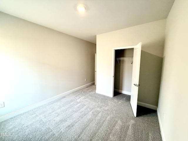 unfurnished bedroom featuring carpet, baseboards, and a closet