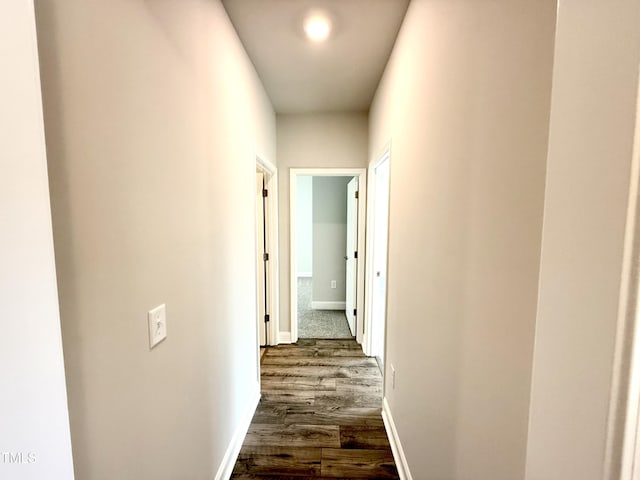 hall featuring dark wood finished floors and baseboards