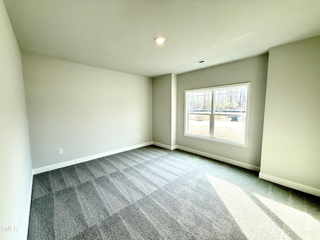 unfurnished room featuring visible vents, carpet, and baseboards