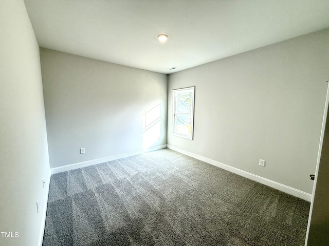 spare room featuring baseboards and carpet floors