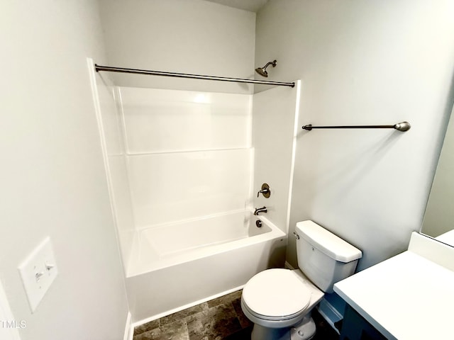 bathroom featuring stone finish floor, toilet, vanity, and shower / bathing tub combination