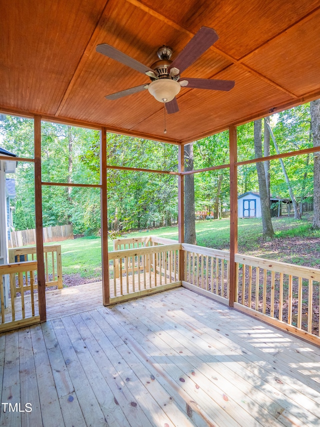 unfurnished sunroom featuring a wealth of natural light, ceiling fan, and wooden ceiling