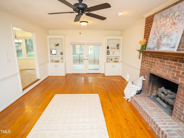 living room featuring a fireplace, hardwood / wood-style flooring, ceiling fan, and crown molding