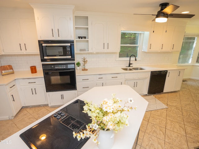 kitchen with white cabinetry, black appliances, and tasteful backsplash