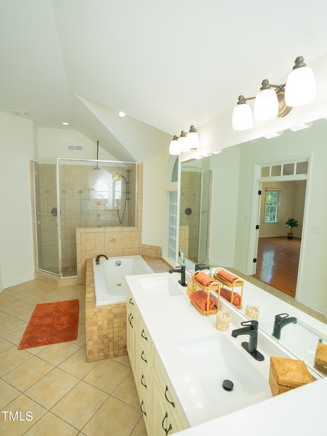 bathroom featuring tile patterned flooring, vanity, separate shower and tub, and vaulted ceiling