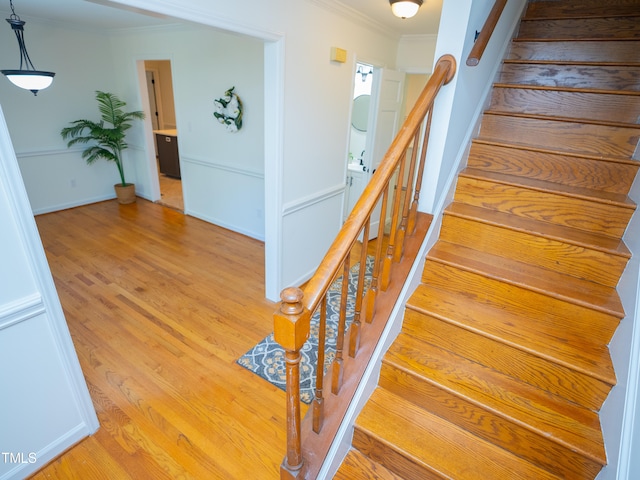 staircase with hardwood / wood-style flooring and crown molding