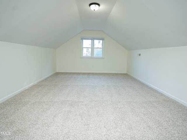 additional living space featuring lofted ceiling and carpet