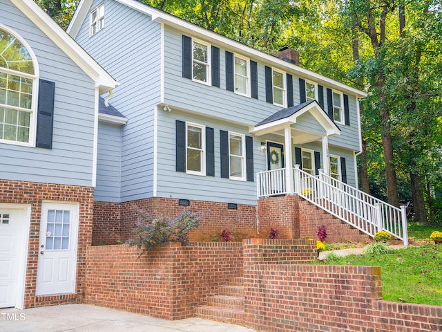 colonial home with a garage and covered porch