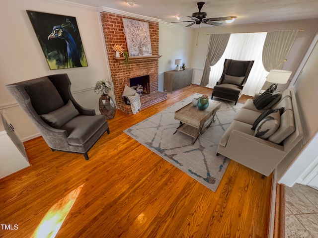 living room with a fireplace, ceiling fan, light wood-type flooring, and ornamental molding