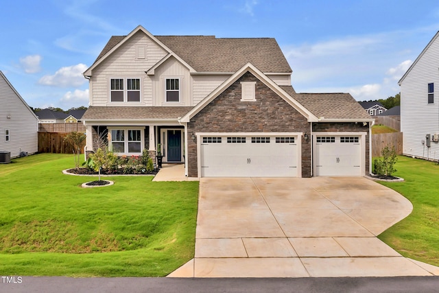 craftsman-style house featuring a front yard, a garage, and central AC unit