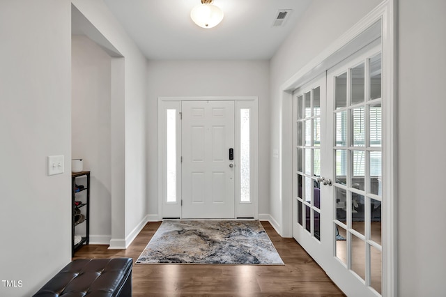 entrance foyer with dark hardwood / wood-style floors, french doors, and a wealth of natural light