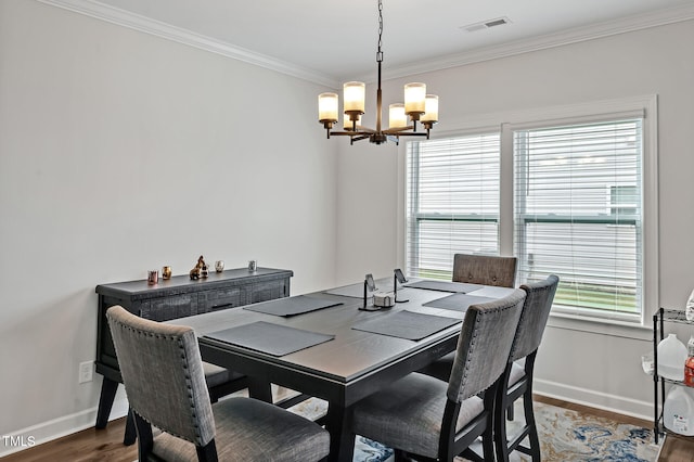 dining room with a notable chandelier, dark hardwood / wood-style floors, and ornamental molding