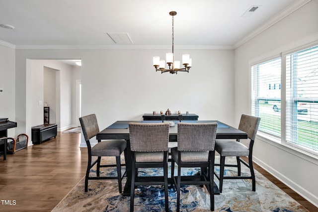 dining space with ornamental molding, an inviting chandelier, and dark hardwood / wood-style flooring