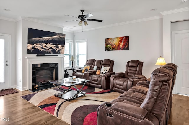 living room featuring wood-type flooring, ornamental molding, and ceiling fan