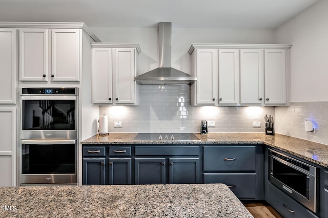 kitchen featuring wall chimney exhaust hood, white cabinetry, and stainless steel appliances