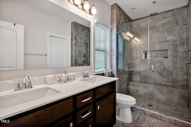 bathroom with tile patterned flooring, vanity, toilet, and a shower with door