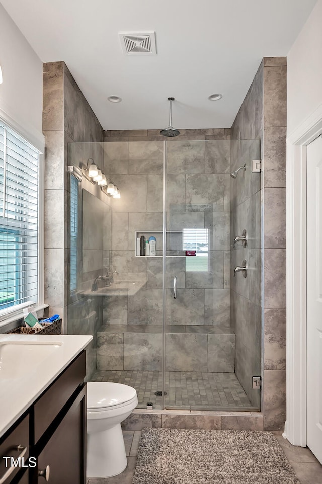 bathroom with vanity, toilet, an enclosed shower, and tile patterned floors