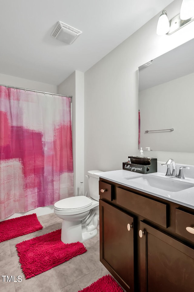 bathroom with tile patterned flooring, vanity, and toilet