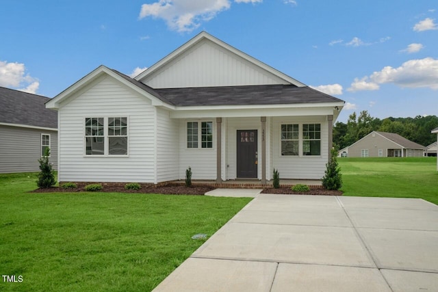 view of front of property featuring a front yard, board and batten siding, roof with shingles, and a porch