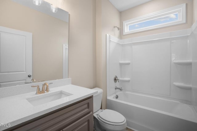 bathroom with toilet, vanity, and shower / tub combination