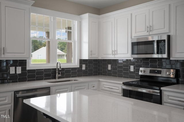 kitchen with stainless steel appliances, a sink, and white cabinets