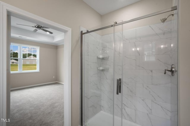 bathroom with a marble finish shower, a raised ceiling, baseboards, and ceiling fan