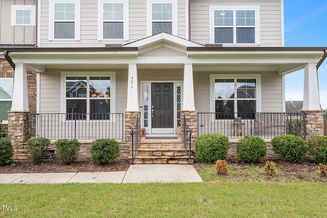 entrance to property with a lawn and a porch