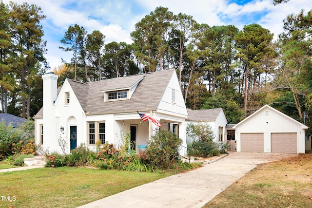 view of front facade with an outbuilding, a front lawn, and a garage