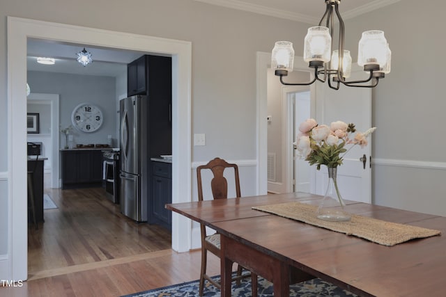 dining space with an inviting chandelier, crown molding, and dark hardwood / wood-style flooring