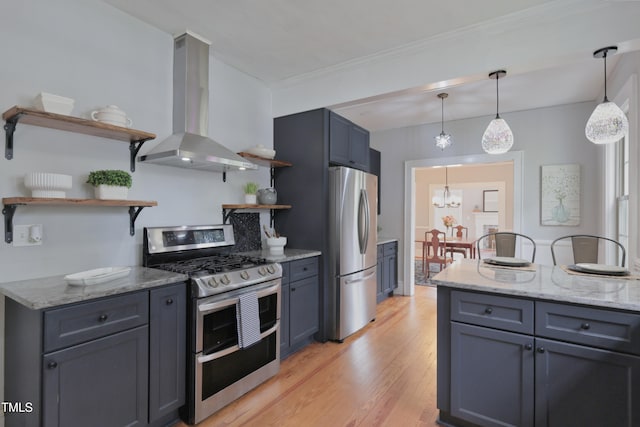 kitchen with light stone countertops, appliances with stainless steel finishes, light hardwood / wood-style floors, wall chimney exhaust hood, and pendant lighting