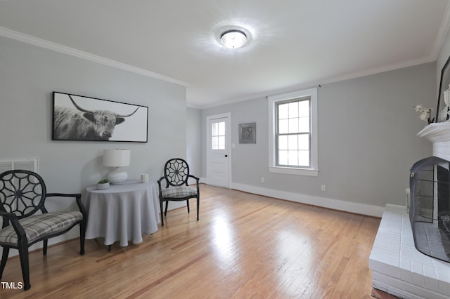 sitting room featuring light hardwood / wood-style floors and crown molding