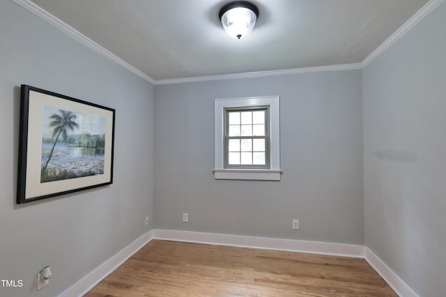 spare room with ornamental molding and light hardwood / wood-style flooring