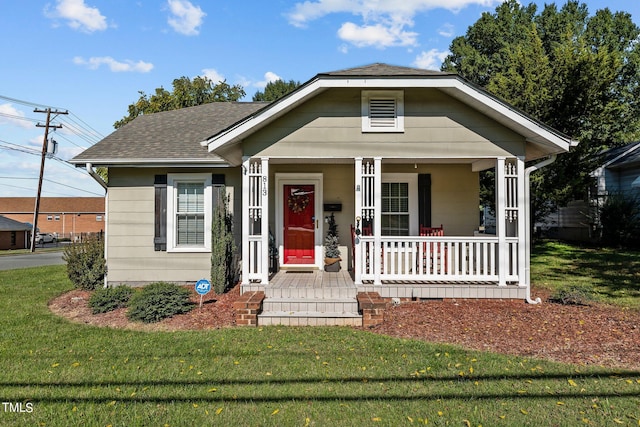 bungalow-style house featuring covered porch and a front yard