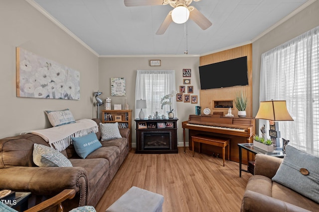 living room with plenty of natural light, crown molding, light hardwood / wood-style flooring, and ceiling fan