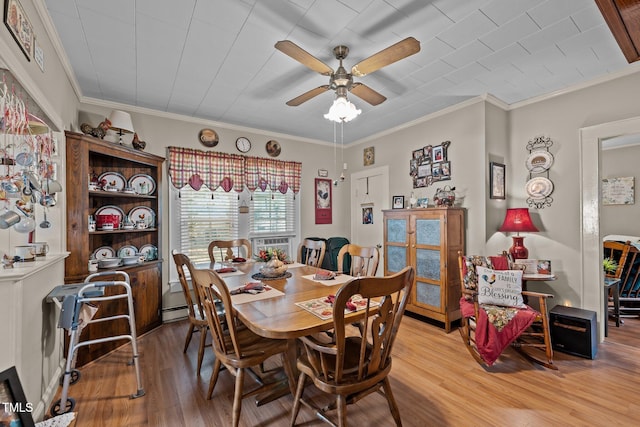 dining area with ceiling fan, ornamental molding, baseboard heating, and hardwood / wood-style floors