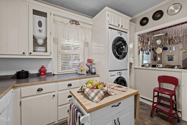 kitchen featuring white cabinetry, water heater, a baseboard radiator, crown molding, and stacked washer and dryer