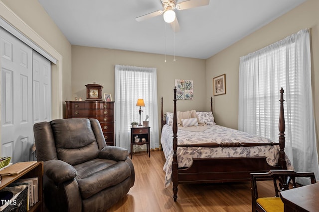 bedroom with a closet, light hardwood / wood-style flooring, and ceiling fan