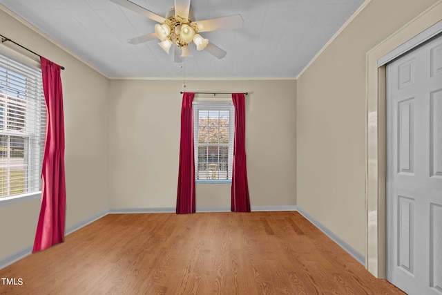 spare room featuring ceiling fan, light wood-type flooring, and crown molding