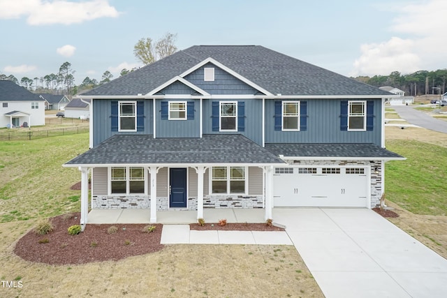 view of front of home with covered porch, stone siding, and roof with shingles