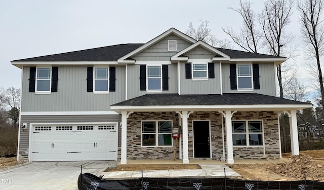 view of front of property featuring concrete driveway, stone siding, an attached garage, covered porch, and board and batten siding