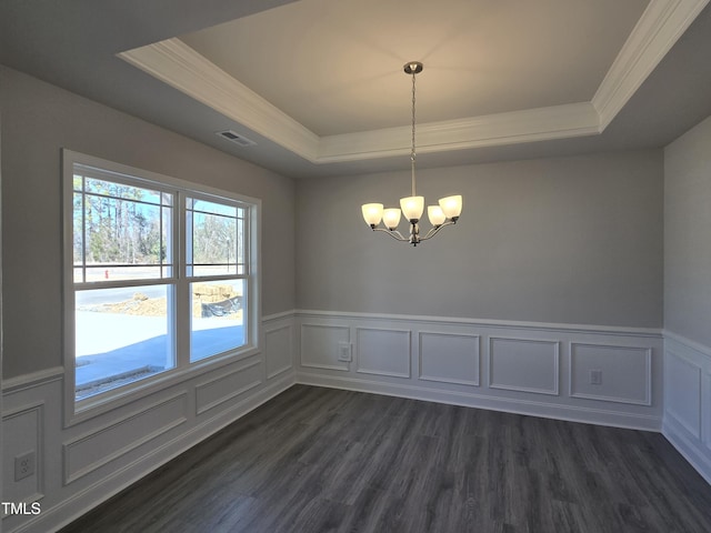 empty room featuring dark wood finished floors, a raised ceiling, and visible vents