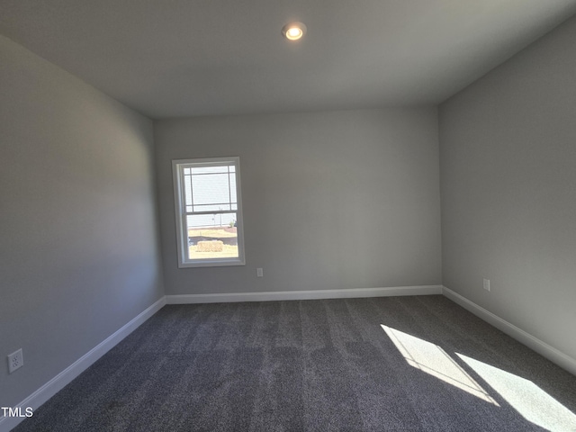 unfurnished room with baseboards, dark carpet, and recessed lighting