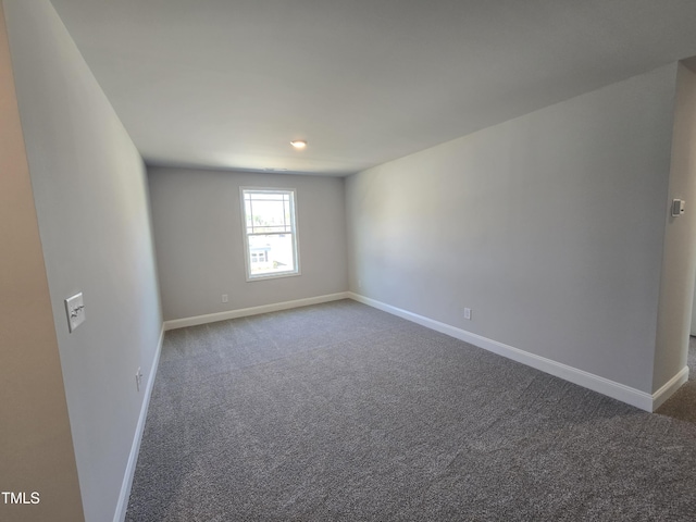 spare room with carpet and baseboards