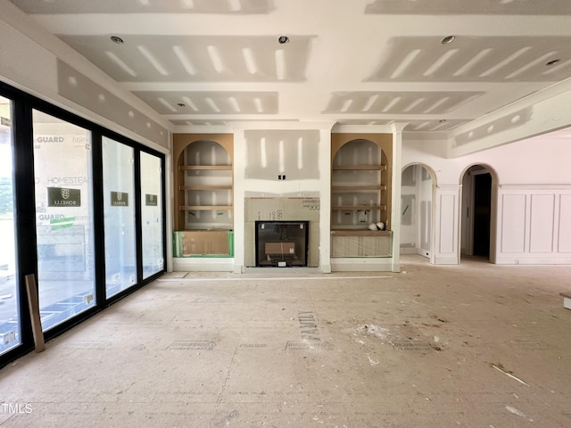 7000 N Ridge Dr, Raleigh, NC 27615 - unfurnished living room featuring built in features, arched walkways, and a glass covered fireplace